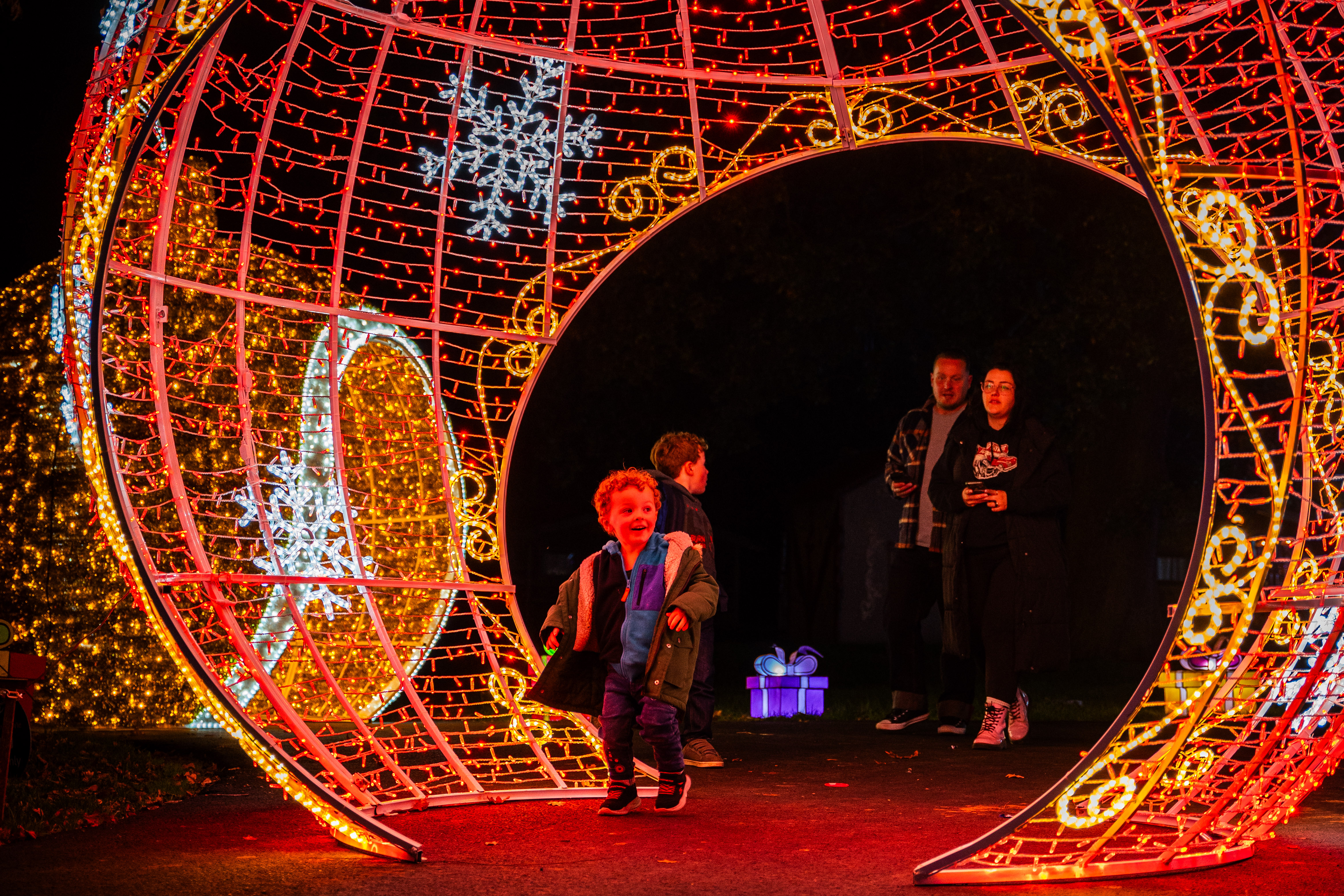 Children running through christmas lantern display